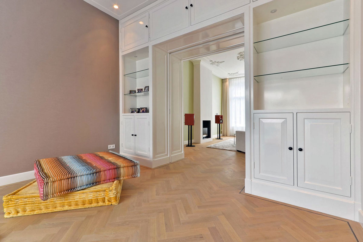 Moderne witte keuken met hout en verlichting ontwerp door binnenhuis architect Maxim Winkelaar.