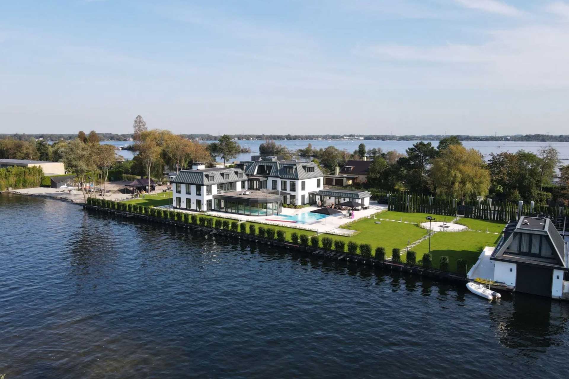 Nieuwbouwvilla-Vinkeveen-luchtfoto achter Nieuwbouw Villa Vinkeveen in wit klassieke architectuurstijl met binnen en buiten zwembad.